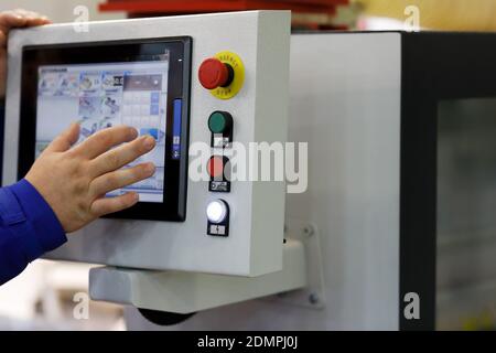 Working with touchscreen control panel of industrial equipment. Selective focus. Stock Photo