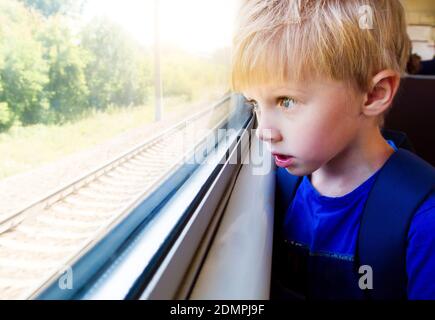 Surprised Kid in the Train by the Window Stock Photo