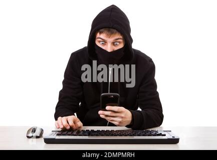 Surprised Hacker with a Mobile Phone and the Computer Keyboard on the White Background Stock Photo