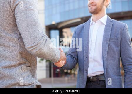 Cropped shot of two businessmen shaking hands outdoors. Unrecognizable male entrepreneurs shaking hands, sealing the deal Stock Photo