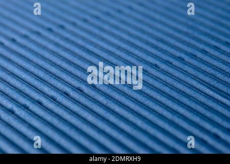 Background made of blue corrugated cardboard with diagonal stripes, shallow depth of field. Stock Photo