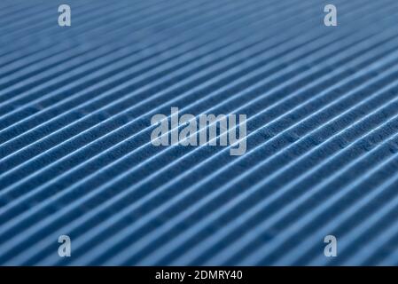 Background made of blue corrugated cardboard with diagonal stripes, shallow depth of field. Stock Photo