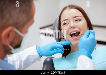 Close up of a lovely young woman having her teeth examined by dentist Stock Photo