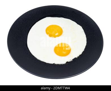 two fried eggs on black plate isolated on white background Stock Photo