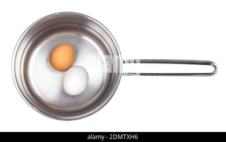 top view of two eggs in saucepan with water isolated on white background Stock Photo
