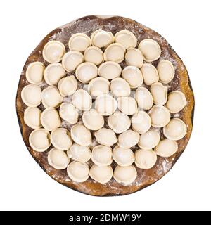 top view of many frozen Pelmeni (russian dumplings filled with minced meat) on wooden board isolated on white background Stock Photo