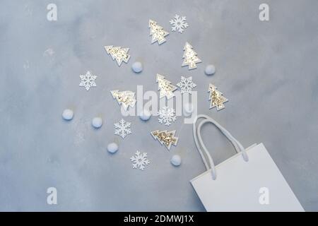 Christmas mockup shopping concept. Kraft white package with snowflakes and fir tree with place for your text on gray background. New Year flat lay Stock Photo