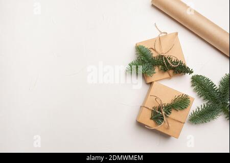 Christmas composition with green fir branches and kraft paper gift boxes on white background, Top view with copyspace Stock Photo
