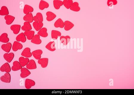 The background of Valentine's day. Small red hearts on a pink background. The concept of love and happiness. Stock Photo