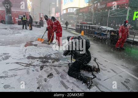 New York, United States. 16th Dec, 2020. Heavy snow and high wind as first winter storm of the season hit New York. Workers shovel snow on Times Square. Forecast prediction for up to 14 inches of snow in the city when storm will move away late afternoon next day. (Photo by Lev Radin/Pacific Press) Credit: Pacific Press Media Production Corp./Alamy Live News Stock Photo