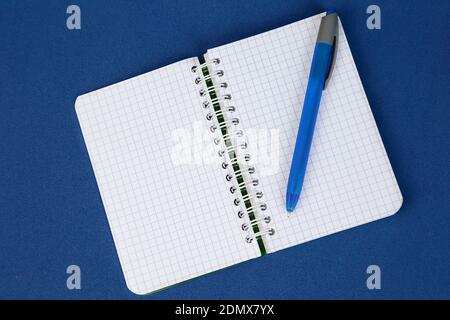 Open notepad and a pen on blue background. Writing concept. Stock Photo