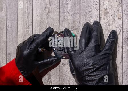 electrician installs an electric light switch on the wall Stock Photo