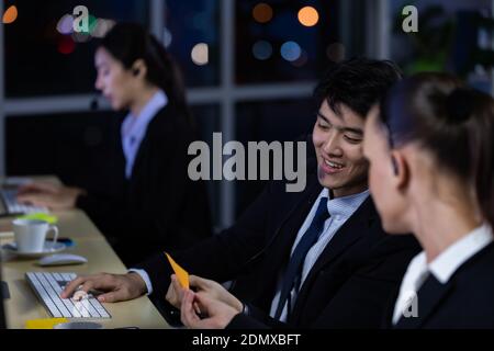 Businessman talking with team and working overtime late at night in call center office. Concept for business at night. Stock Photo