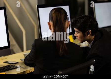 Businessman talking with team and working overtime late at night in call center office. Concept for business at night. Stock Photo