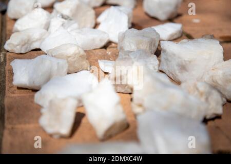 white quartz stones for the sauna lie on the tiles dry after cleaning service Stock Photo