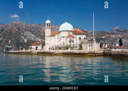 Perast, Kotor, Montenegro. View across tranquil water to the Church of Our Lady of the Rocks, Bay of Kotor. Stock Photo