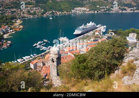 Kotor, Montenegro. View over the tiled rooftops of the Old Town from the city walls, the cruise ship Azamara Journey in port. Stock Photo