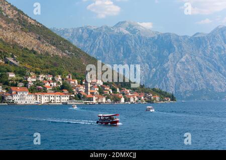 Perast, Kotor, Montenegro. Ferry boats shuttling tourists back and forth across the Bay of Kotor to the Church of Our Lady of the Rocks. Stock Photo