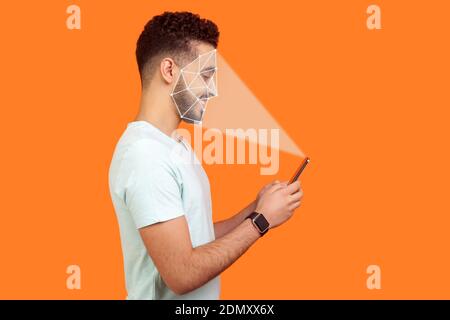 Mobile biometric identification and verification or detection concept. face ID scaning or unlocking technology. happy man using facial recognition on Stock Photo