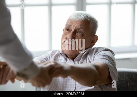 Professional nurse caregiver help senior sick man to raise up Stock Photo