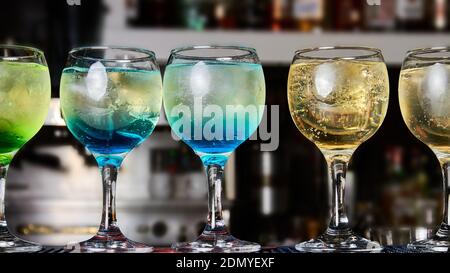 Multicolored alcoholic and non-alcoholic cocktails with ice on the bar counter Stock Photo