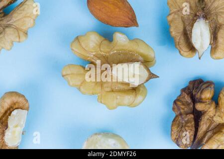 Nuts, walnuts, almonds and hazelnuts on a blue background, macro image Stock Photo