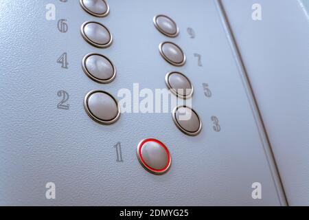 Metal Elevator buttons close up from bottom to top. Button on the number one is red Stock Photo