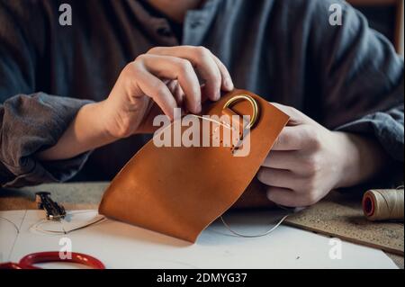 Desktop in the shoemaker workshop. The process of making leather shoes. Hands close-up without a face. Stock Photo