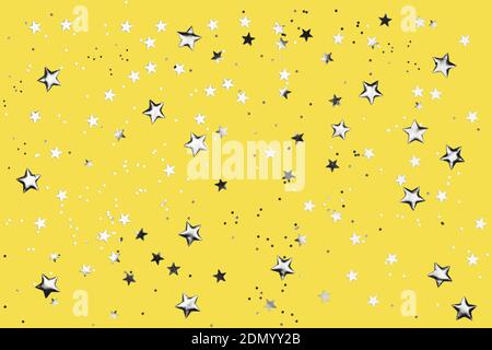 Yellow background with shiny silver glitter on it. Dots, stars and little sparkles in flat lay stile. Festive concept. Stock Photo