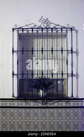 A vertical shot of a vase of a plant on the window with a tiled wall Stock Photo