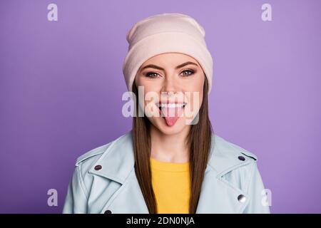 Closeup photo of good mood pretty lady street clothes smiling white teeth sticking tongue out mouth teasing behavior wear casual hat blue modern Stock Photo