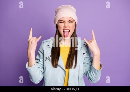 Photo of crazy funky pretty lady sticking tongue out mouth teasing behavior rocker showing horns hands wear casual hat blue modern jacket isolated Stock Photo
