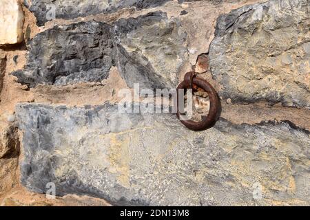 Iron ring anchored in a stone facade, used in the past to tie up cavalry. Stock Photo