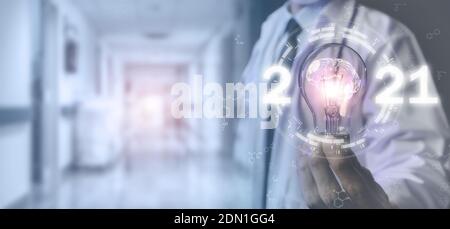 2021 medical futuristic technology trends concept, doctor hold the light bulb wiht brain medical technology in 2021 by using artificial intelligence, Stock Photo