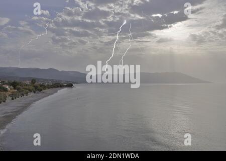 Morning thunderstorm over the bay of Votsalakia on the Greek island of Samos during the sunrise. Stock Photo