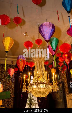 UK, England, Derbyshire, Edensor, Chatsworth House Guest Bedroom at Christmas, Lands Far Away, China, paper and fabric lanterns by ceiling chandelier Stock Photo