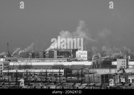 Smoke comes from industrial red-white pipes. Industrial zone environmental pollution selective focus Stock Photo