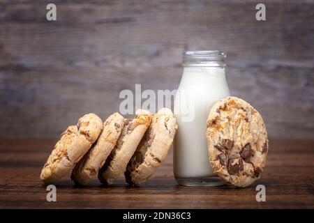 Chocolate chip cookies and a small bottle of milk Stock Photo