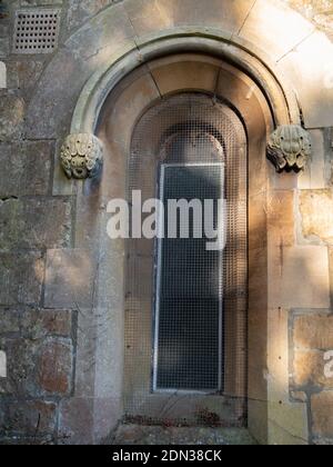 Round arched window with clasping buttresses on Holy Trinity Church, Dilton Marsh, Wiltshire, England, UK. Stock Photo