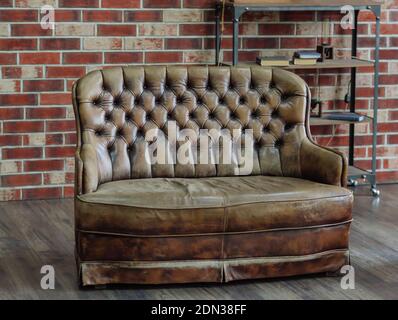 Retro sitting room with leather couch and brick background wall, loft interior Stock Photo