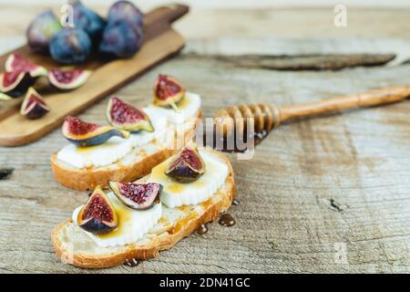 Figs with fresh cheese on toast Copy space. Stock Photo
