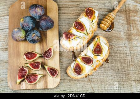 Figs with fresh cheese on toast Copy space. Stock Photo