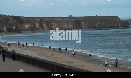 Seaham beach and promenade in County Durham with people walking along the beach while keeping socially distanced during the 2020 pandemic Stock Photo
