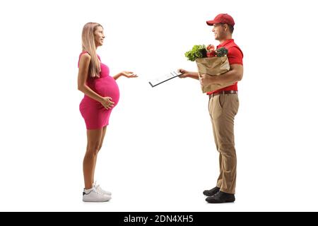 Full length profile shot of a courier with a bag of groceries giving a document to a pregnant woman isolated on white background Stock Photo