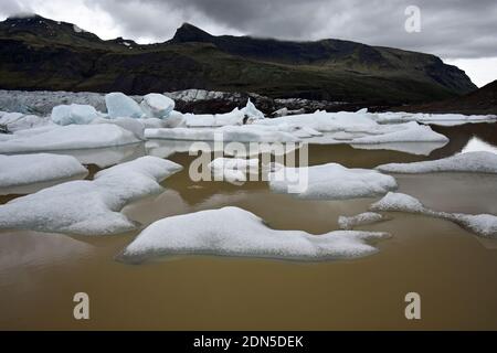 The Svínafelljokull glacier as it flows into the glacial lagoon in Vatnajokull National Park, South Iceland. Chunks of ice float in the lake. Stock Photo