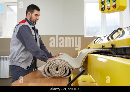Man operating carpet automatic washing machine in professional laundry service Stock Photo