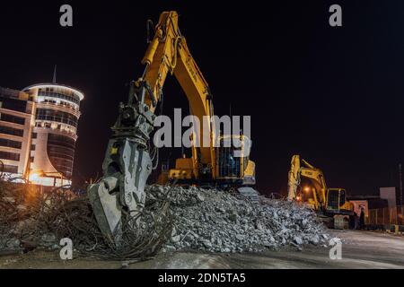 Hydraulic excavator clears the debris of demolished building. Stock Photo