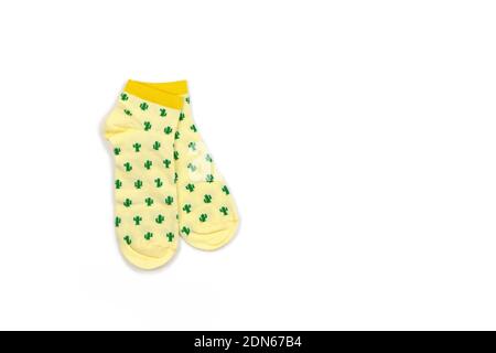 Funny womens or mens, unisex, cropped yellow socks with green cacti isolated on white background, copy space, flat lay. Fashion concept, unusual, tren Stock Photo