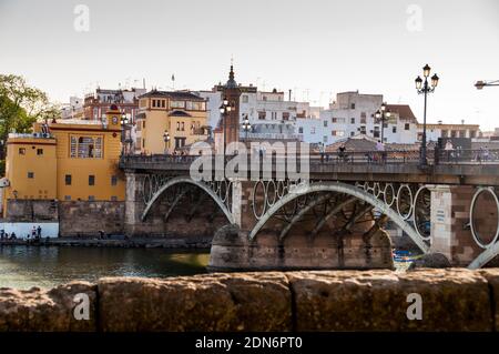 River Guadalquivir and Puenta de Triana  or Puente de Isabel II Bridge from Triana to old town Seville, Spain. Stock Photo