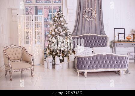 Stylish New Year's bedroom interior is decorated in white and gray colors. Stock Photo